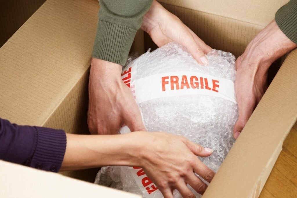 Wrapping fragile items with quality  bubble wrap inside a box.