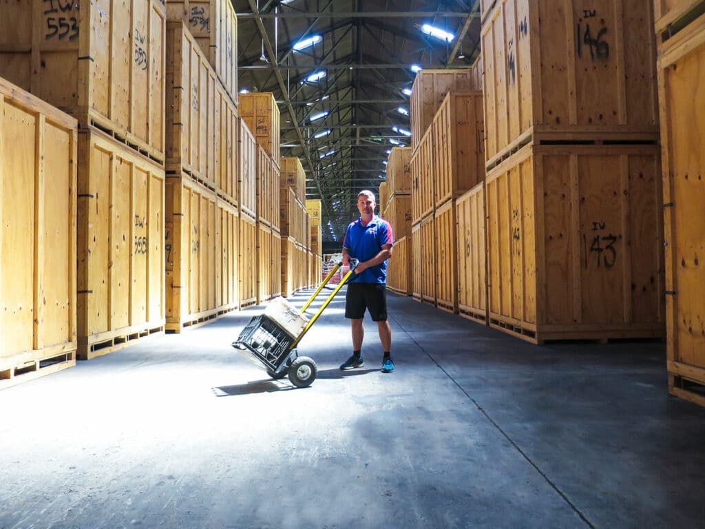 Worker moving storage crate inside a warehouse.