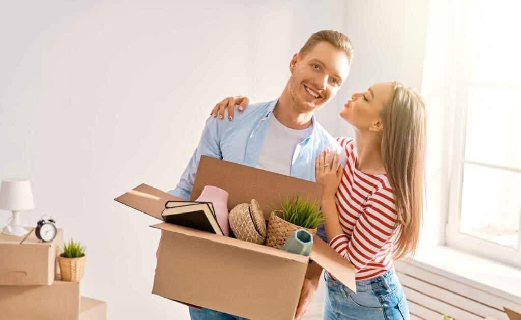 Couple holding a moving box while planning an interstate move.