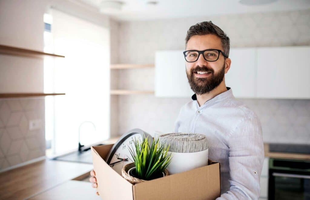 Man holding a moving box, illustrating interstate moving costs.