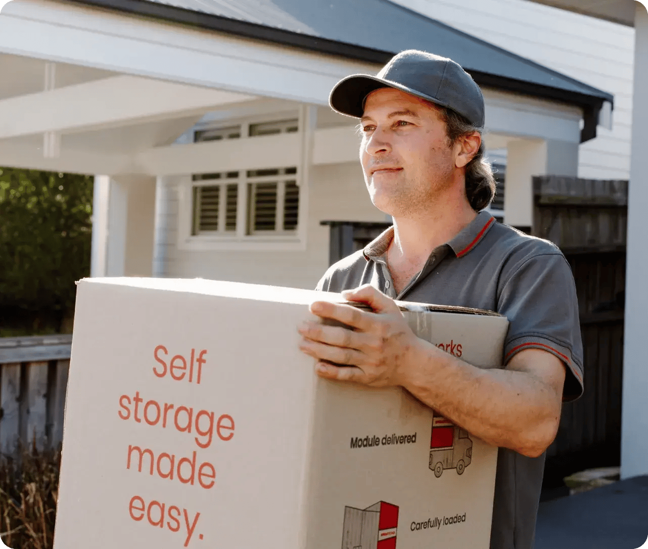 Super Easy Storage team member carrying a storage box outside a home
