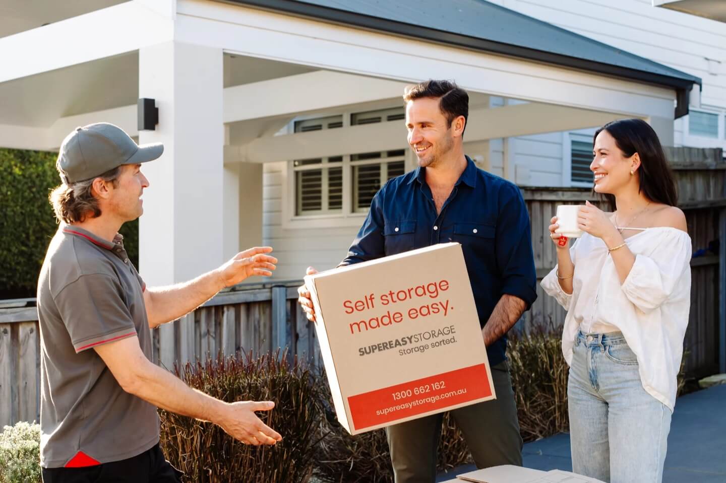 Super Easy Storage team member carrying a storage box outside a home