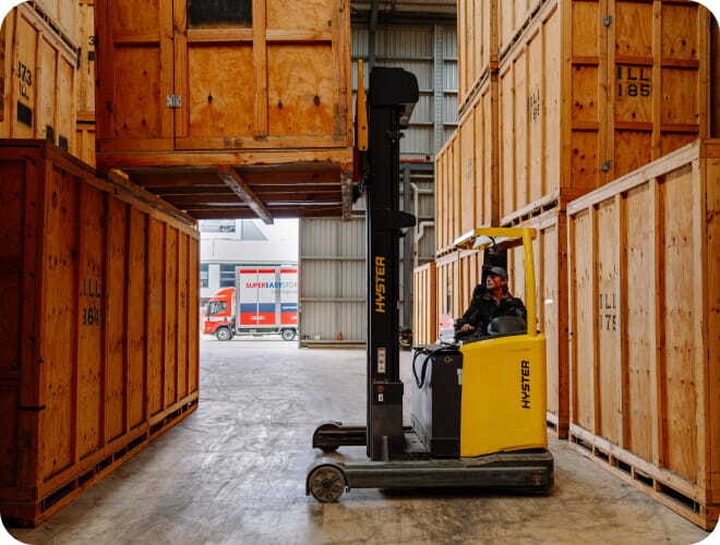 Forklift moving through container storage aisles